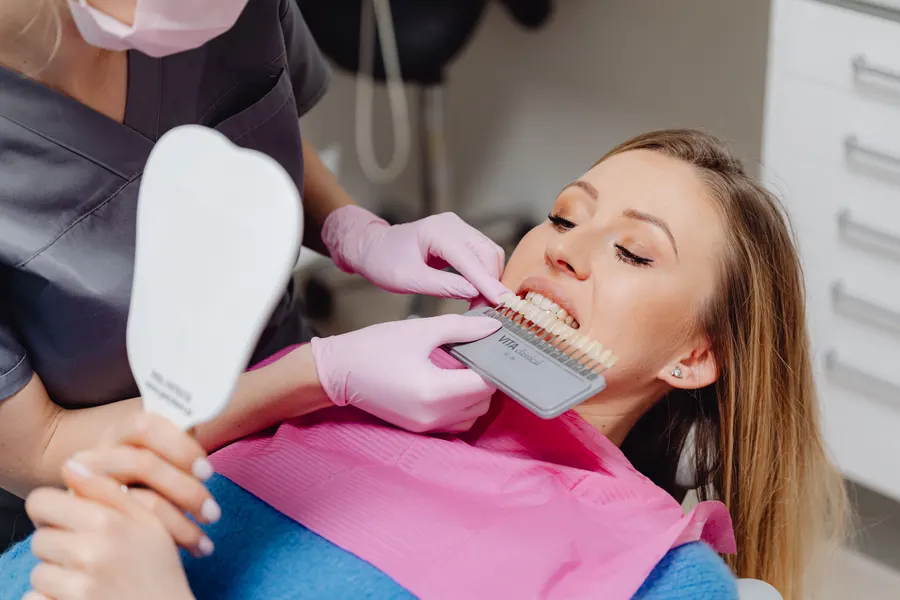 Dentista utilizando guia de cores para clareamento dental