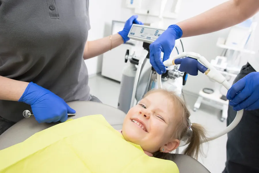 Criança sorrindo durante atendimento odontopediátrico